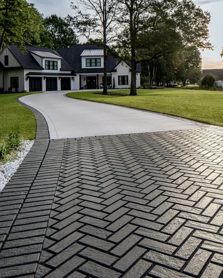 Herringbone paver driveway leading to a home
